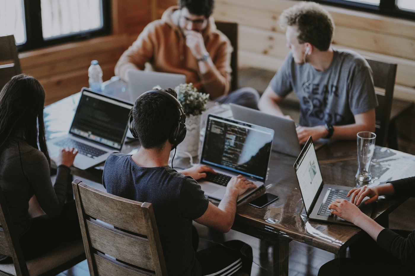 The Veyrisha Labs team collaborating around a studio table with laptops
